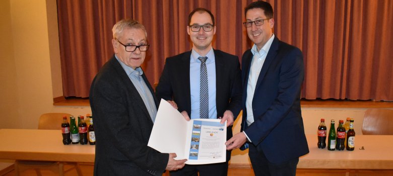Landrat Schnur (li.), Bürgermeister der VG Zell Hoffmann (re.) sowie Ortsbürgermeister Fischer (Mitte) mit der Urkunde
