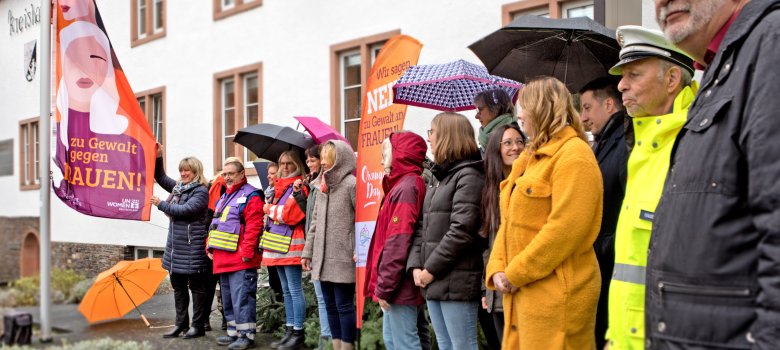 Landrätin Anke Beilstein und die Gleichstellungsbeauftragte des Landkreises Cochem-Zell hissen eine Fahne mit Wortlaut: „Wir sagen Nein zu Gewalt an Frauen!“