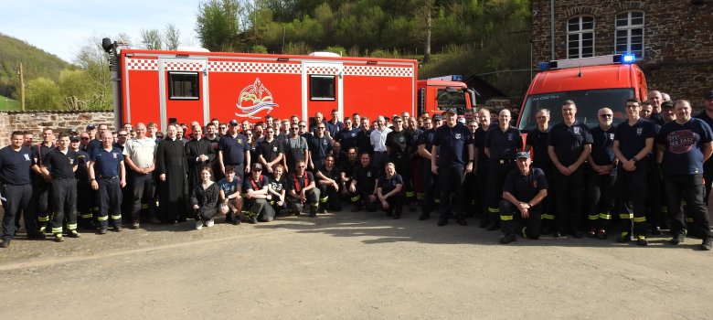 Gruppenbild von Feuerwehrleuten vor einem Feuerwehrauto