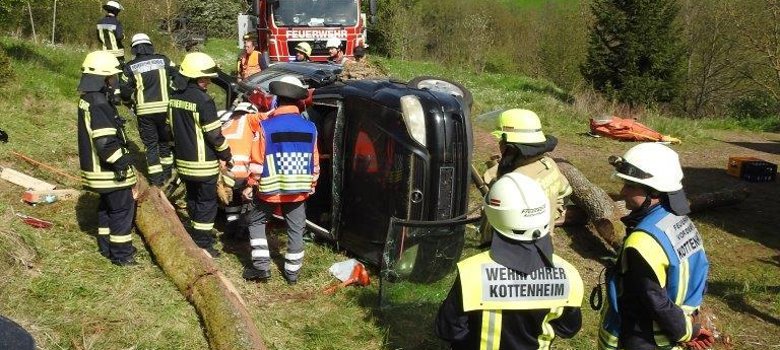 Ein auf der Seite liegendes Auto umgeben von Rettungskräften