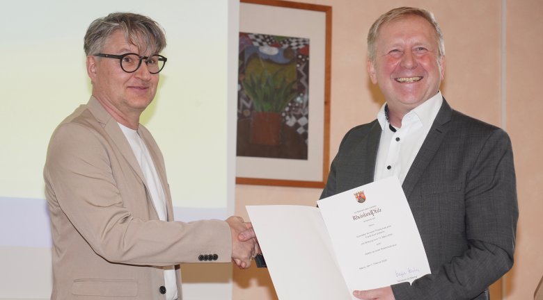 Frank Sütterlin (links) bekommt die Ernennungsurkunde zum Rektor durch den Regierungsschulrat Achim Buchholz überreicht
