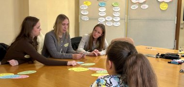 Büro Landrätin Zu sehen sind vier Mädchen die an einem Tisch sitzen. Im Hintergrund stehen zwei Pinnwände