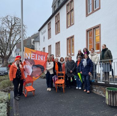 Zu sehen sind die Vertreterinnen des Soroptimist Club Cochem/ Mosel und der Caritas, die mit Landrätin Anke Beilstein und der Gleichstellungsbeauftragten des Landkreises Vanessa Krüger eine Fahne vor dem Kreishaus hissen.
