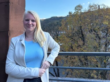 Zu sehen ist Lea Heinzen, die außerhalb der Kreisverwaltung steht. Im Hintergrund scheint die Sonne.