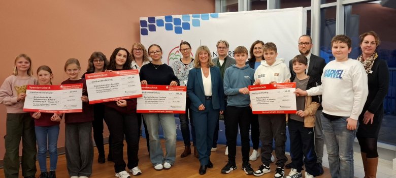 Gewinner Schulwettbewerb Zu sehen ist eine Schülergruppe, inmitten Landdrätin Frau Beilstein. Einige Schüler halten Preise in den Händen. Im Hintergrund ist das Banner des Landkreis Cochem-Zell zu sehen.