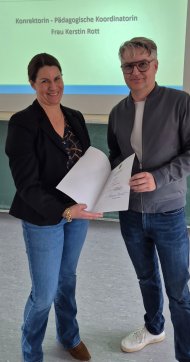 Kerstin Rott zur Pädagogischen Koordinatorin ernannt Zu sehen sind Kerstin Rott und Schulleiter Sütterlin. Kerstin Rott hält ihre Auszeichnung in ihren Händen.