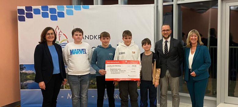 Preisverleihung Schulwettbewerb zum Heimatjahrbuch 2025. Preisverleihung Schulwettbewerb zum Heimatjahrbuch 2025. Das Bild zeigt Schülerinnen und Schüler der Klasse 7a der Realschule plus Vulkaneifel im großen Sitzungssaal der Kreisverwaltung Cochem-Zell. Sie stehen in einer Reihe, ganz rechts steht Landrätin Anke Beilstein, zu sehen sind außerdem zwei Lehrkräfte.