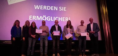 Zu sehen sind von links nach rechts: Landrätin Anke Beilstein, Nicole Jobelius-Schausten (Kreiswerke Cochem-Zell), Angelika & Dirk Brück, Günter Andre, Sonja Weyrauch, Reiner Mohr, Thomas Ranft (Redner; ARD-Klimaexperte). Sie stehen auf der Bühne des Apollo Kinos.