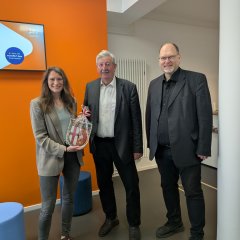 Foto FGZ Cochem (Stadtwappen): Zur Begrüßung in der Ravenéstraße 58 überreicht Bürgermeister Walter Schmitz (Mitte) das Cochemer Stadtwappen an Tina Georgi, örtliche Betriebsleiterin Transdev Vertrieb GmbH. Rechts daneben Thorsten Müller, Verbandsdirektor des SPNV-Nord. 