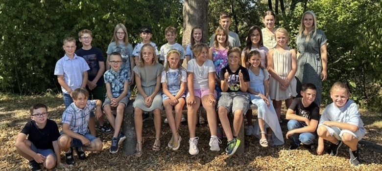 42 neue Fünftklässler starten an der Realschule plus Vulkaneifel Zu sehen sind Schülerinnen und Schüler vor einem Baum. Diese stehen in Reihen. An der rechten Seite steht die Klassenlehrerin.