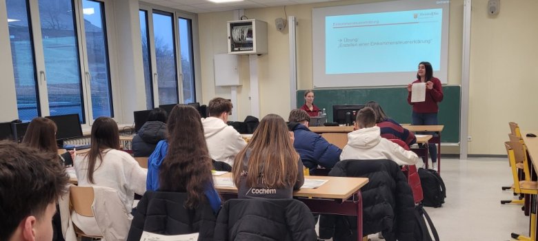 Auf dem Foto zusehen sind die zwei Referentinnen des Finanamtes Simmern, die gerade ihren Vortag halten. Die Schülerinnen und Schüler sitzen auf Ihren Plätzen.