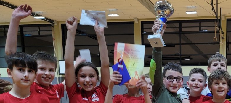 Escher Hallen-Cup begeistert Zuschauer und Teilnehmer Auf dem Bild zusehen ist die Gewinnerklasse 5d der Realschule Plus Kaisersesch. Ein Kind hat einen Umschlag in der Hand. Ein anderes Kind hat eine Urkunde und einen Gutschein in der Hand. Ganz außen hält ein Junge einen Fussball in der Hand.