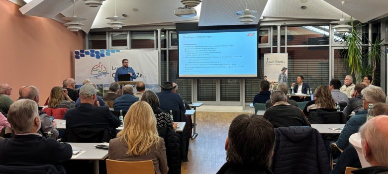 Große Resonanz beim Auftakt zur Einbindung privater PV-Kleinanlagen in das „Virtuelle Kraftwerk Cochem-Zell“. Auf dem Bild zusehen sind einige Personen, die dem Redner zuhören und ein Whiteboard mit einer Präsentation.