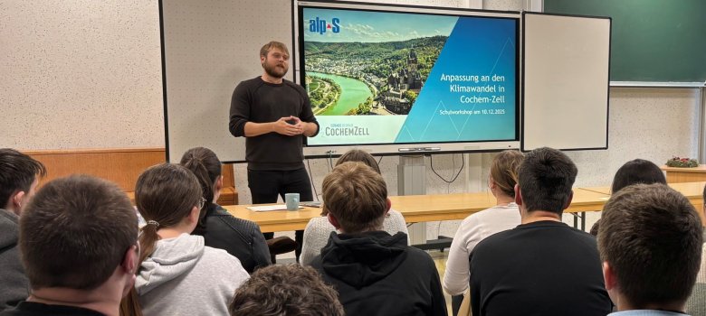Klimaanpassung macht Schule - Klimaanpassungsmanager Dominik Zell steht im Klassenraum vor einer Klasse und informiert mithilfe eine Präsentation über den Klimawandel.