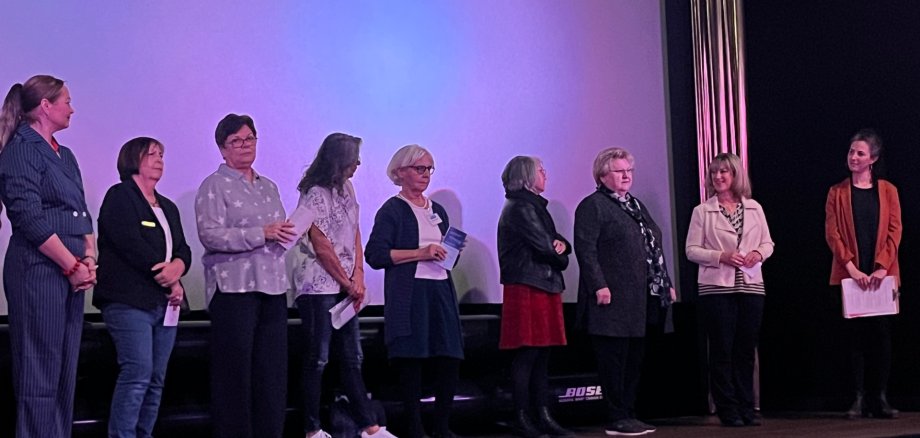 Internationaler Frauentag in Cochem: Großer Zuspruch bei Benefiz-Filmvorführung Internationaler Frauentag in Cochem: Großer Zuspruch bei Benefiz-Filmvorführung - die Veranstalterinnen stehen gemeinsam in einer Reihe vor der Kinoleinwand und begrüßen das Publikum.