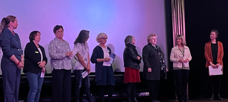 Internationaler Frauentag in Cochem: Großer Zuspruch bei Benefiz-Filmvorführung Internationaler Frauentag in Cochem: Großer Zuspruch bei Benefiz-Filmvorführung - die Veranstalterinnen stehen gemeinsam in einer Reihe vor der Kinoleinwand und begrüßen das Publikum.