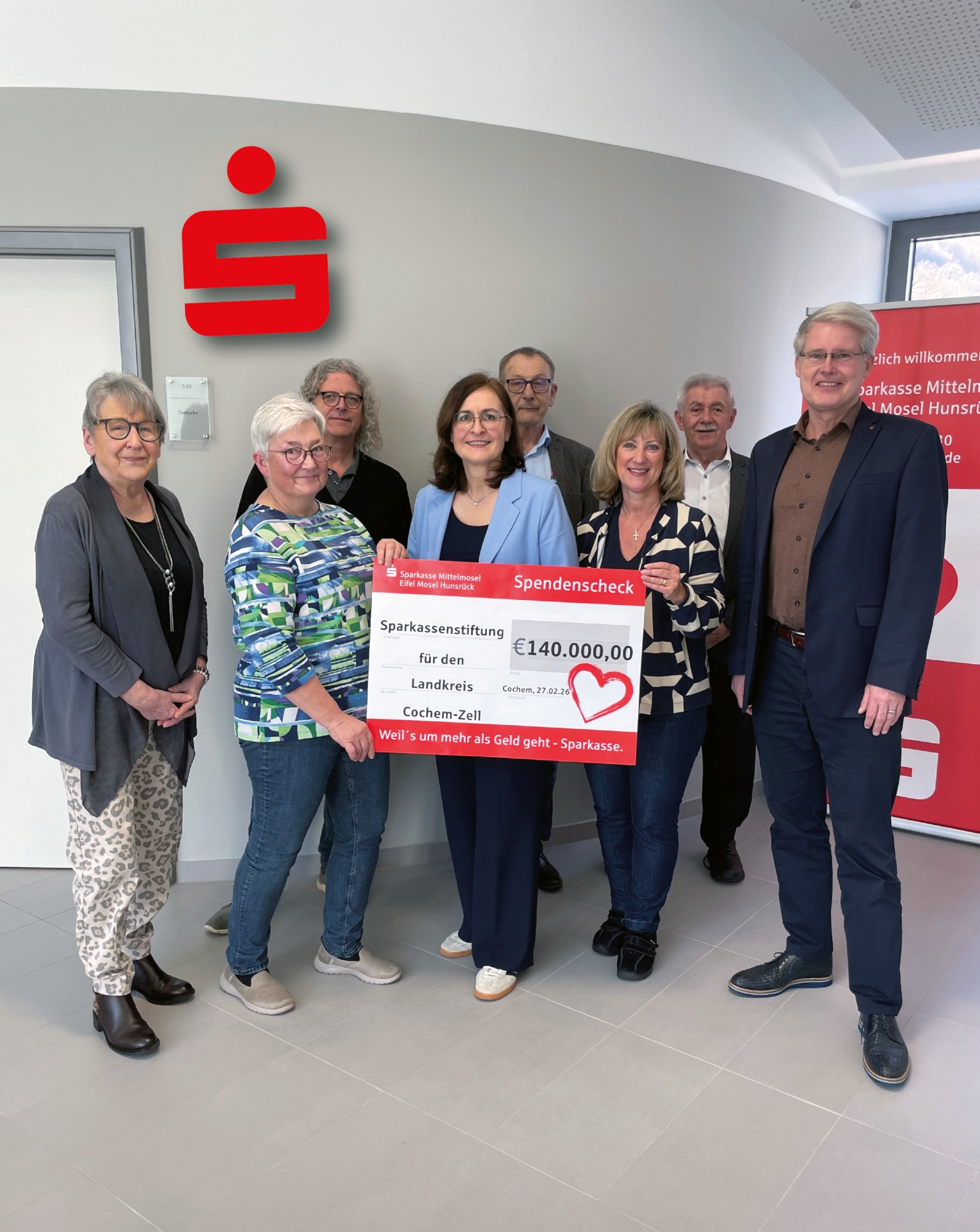 Das Foto zeigt v.l.: Inge Krämer, Hildegard Moritz, Thomas Krämer, Bettina Pellio, Geschäftsführerin, Helmut Braunschädel, Landrätin Anke Beilstein, Andreas Peifer und Eric Westerheide, Vorsitzender des Vorstandes Sparkasse. Die Personen in der Mitte halten einen großen Symbolscheck in den Händen, auf dem der gespendete Betrag zu lesen ist.