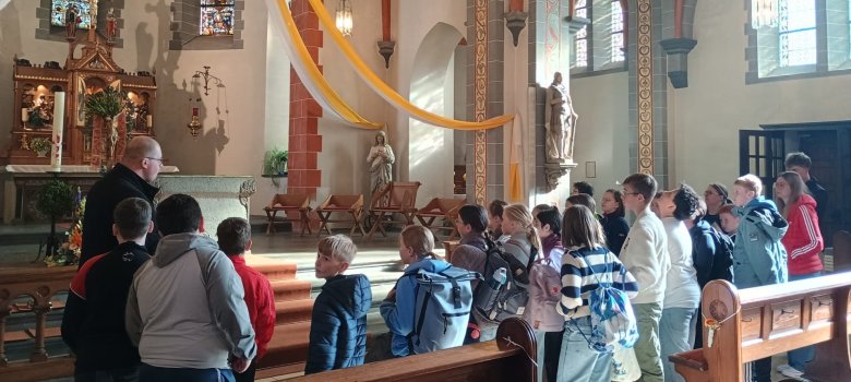 Zu sehen sind die Schüler und Schülerinnen in der Kirche vor dem Altar