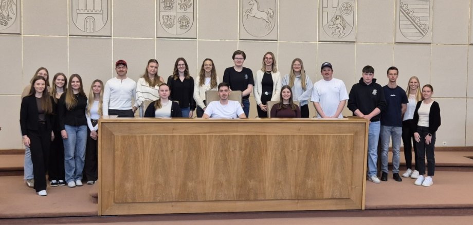 Zwischen Geschichte und Politik: Bildungsfahrt der Nachwuchskräfte nach Bonn Zu sehen sind alle Nachwuchskräfte im ehemaligen Bundesrat, welche ein Gruppenbild am Podest des Saals gemacht haben.