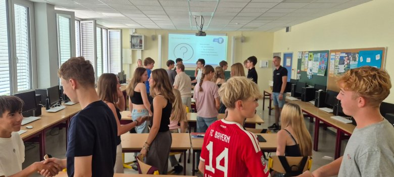 Zur Begrüßung schüttelt man sich die Hand. Zu sehen sind einige Schülerinnen und Schüler die sich gerade gegesenseitig die Hand geben.