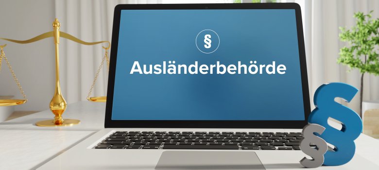 Ausländerbehörde – Recht, Gesetz, Internet. Laptop im Büro mit Begriff auf dem Monitor. Paragraf und Waage.