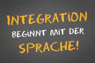 Dargestellt wird ein grauen Hintergrund auf dem in weiß und Gelb folgendes steht: Integration beginnt mit der Sprache!
