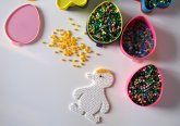 Verschiedene Schälchen mit Bügelperlen. Außerdem ist das Bügelperlenmotiv einer Ente zu erkennen. Verschiedene Schälchen mit Bügelperlen. Außerdem ist das Bügelperlenmotiv einer Ente zu erkennen.