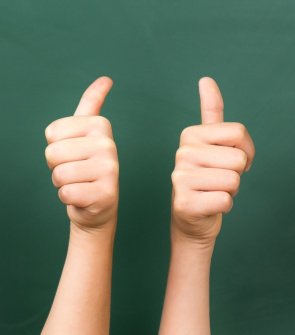 Kinder zeigen Daumen hoch.