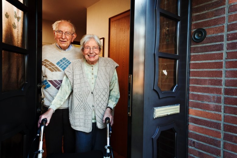 Älteres Paar öffnet eine Haustür.