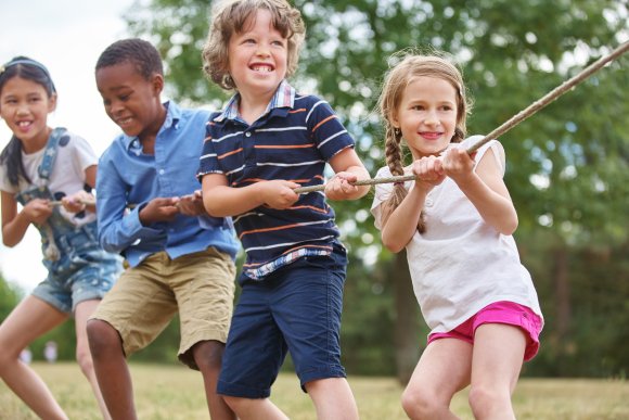 Gruppe Kinder beim Tauziehen.