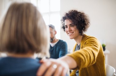 Mann und Frau sitzen in einer Therapiegruppe, um sich gegenseitig Mut zuzusprechen. 