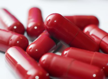 Hier werden Tabletten in einer roten Kapsel dargestellt.