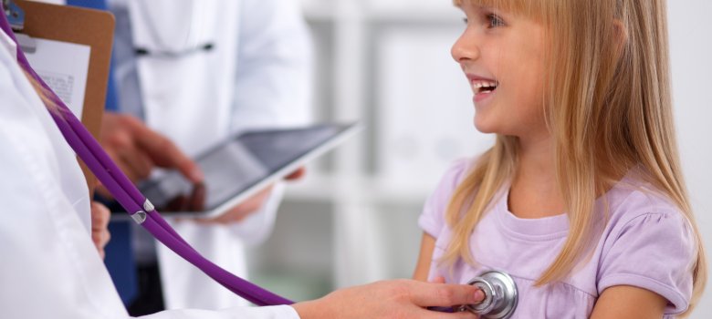 Ein Kind wird von einem Arzt mit dem Stetoskop untersucht. 