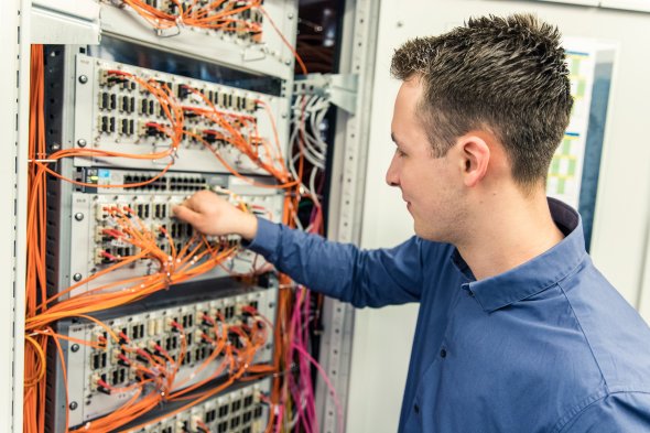 Auf dem Bild wird ein Fachinformatiker für Systemintegration im Serverraum gezeigt Ein Fachinformatiker bei der Arbeit