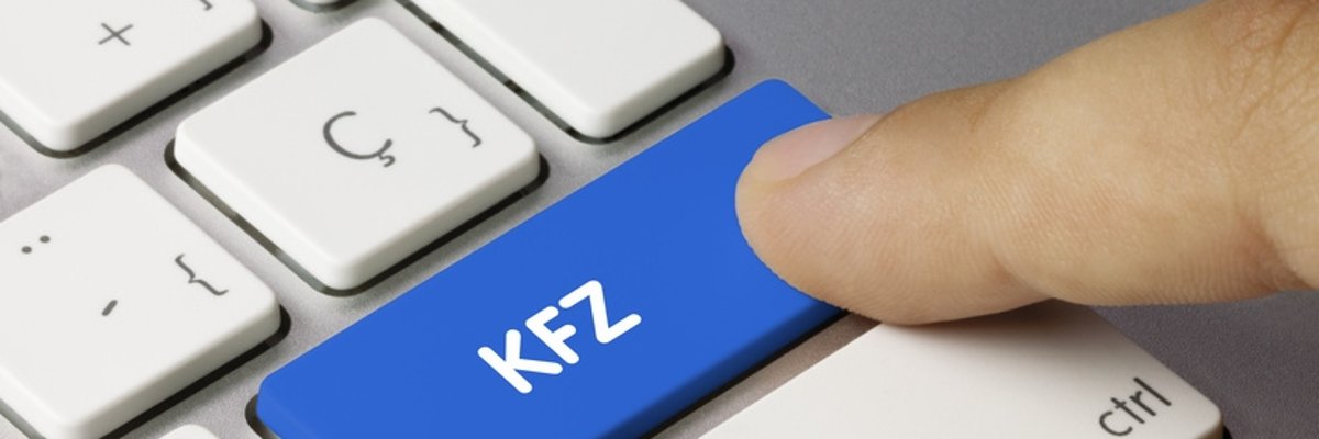 Tastatur mit dem Wort KFZ. Ein Finger tippt auf diese Taste.