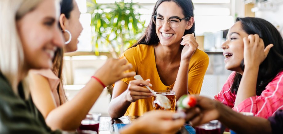 Internationale Gruppe junger Frauen beim Frühstück im Café