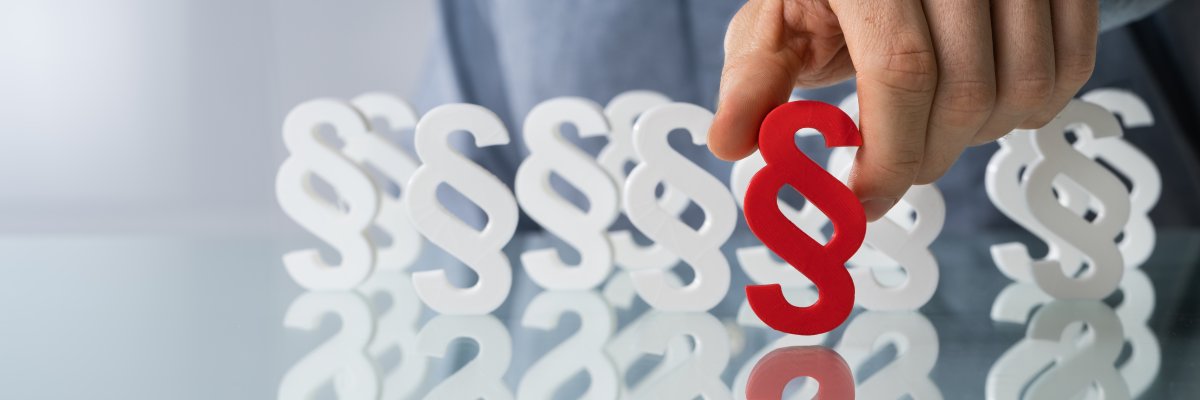 Hand hält ein Paragrafenzeichen Hand hält ein Paragrafenzeichen