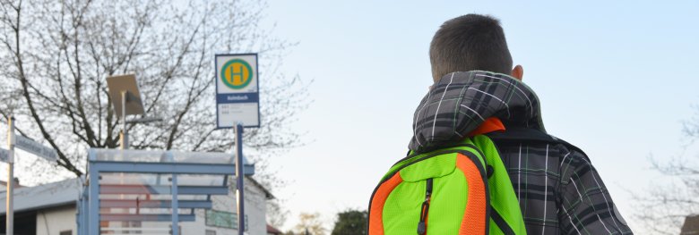 Schüler mit Schulrucksack der Grundschule auf dem morgendlichen Weg zum Schulbus