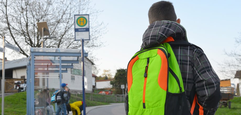 Schüler mit Schulrucksack der Grundschule auf dem morgendlichen Weg zum Schulbus