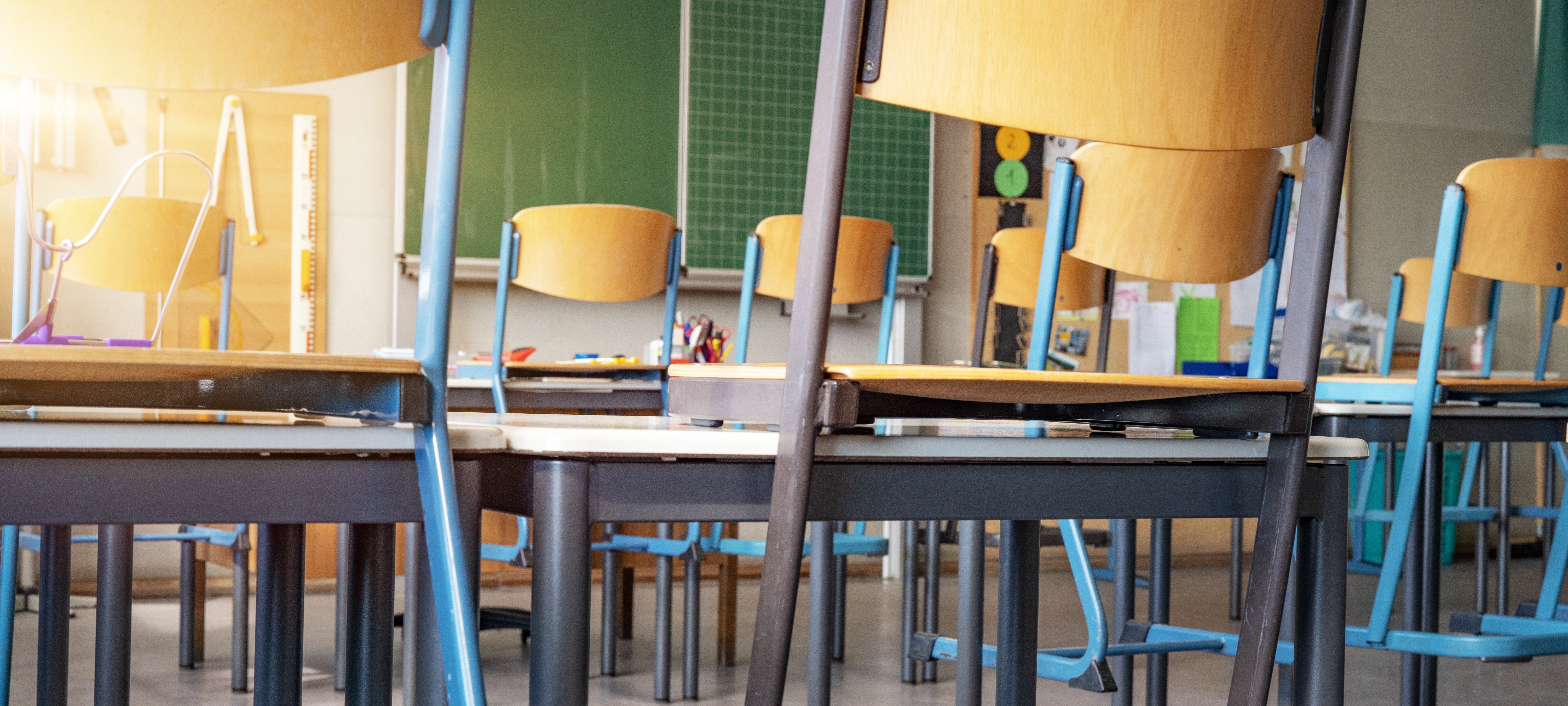 Klassenzimmer mit hochgestellten Stühlen Klassenzimmer mit hochgestellten Stühlen