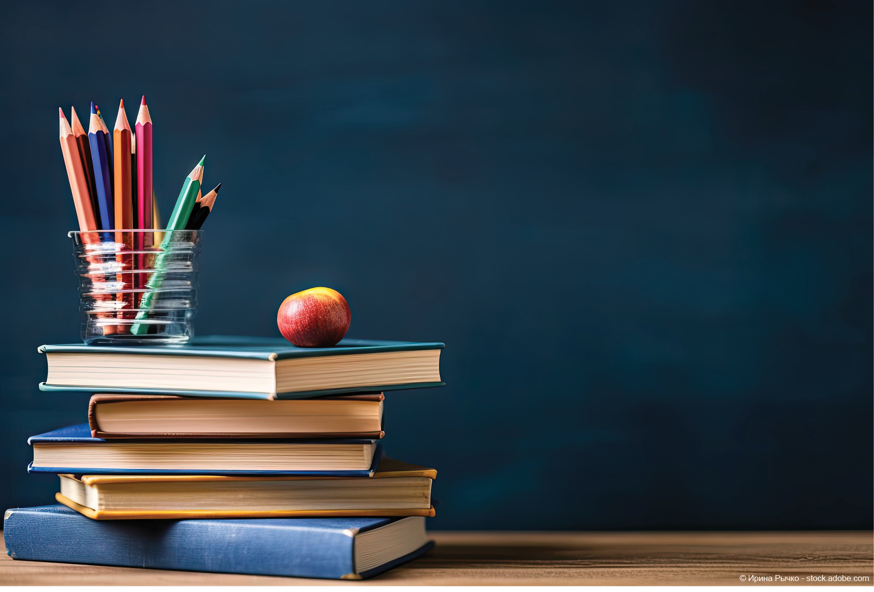 Motivbild Schulbuchausleihe, Stabel Bücher mit Stiftebecher und einem Apfel Logo Schulbuchausleihe Cochem-Zell