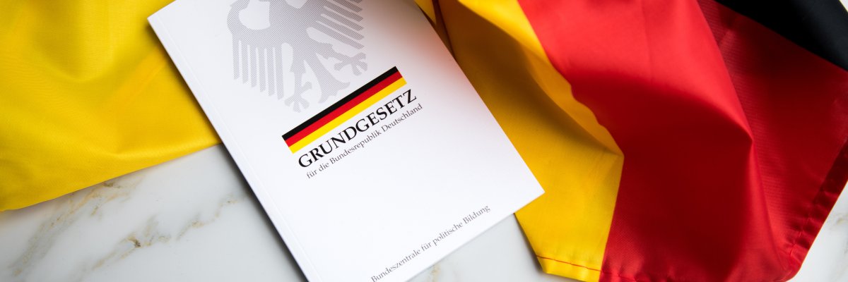 Das Grundgesetz Buch der Bundesrepublik Deutschland auf Flagge.