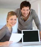 Dargestellt sind zwei junge Menschen, vor einen Laptop. Dargestellt sind zwei junge Menschen, vor einen Laptop.