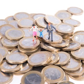 Mann, Frau und Kind laufen über Euromünzen.