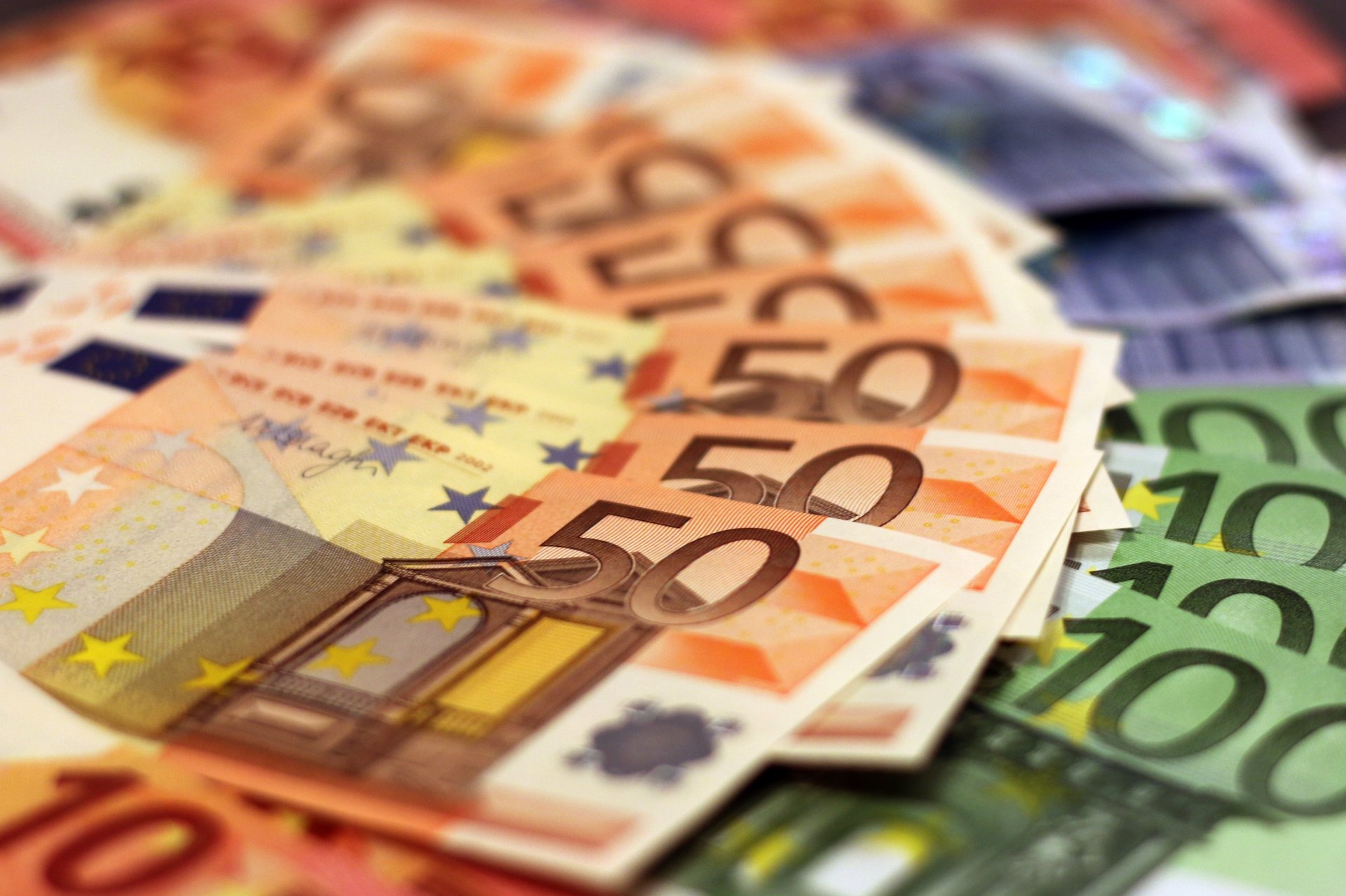 Auf dem Bild sieht man ausgebreitete Euroschein, ganz oben liegen 50-Euro-Scheine, darunter und im Hintergrund sind noch andere Größen erkennbar.